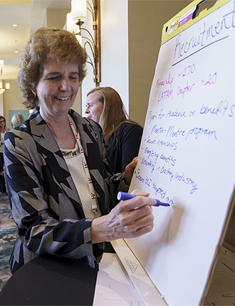 Member of WGBI writing on a flip board at a WGBI event.