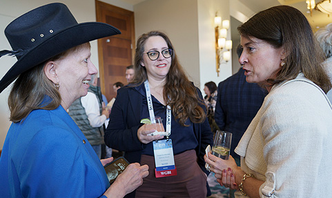 Three women talking at a WGBI networking event.
