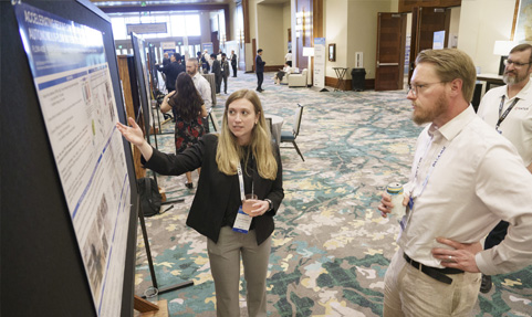 BCI Convention attendee learning about the Battery Research Poster Showcase entries.