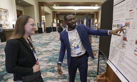 BCI Convention Battery Research Poster Showcase entrant explaining his research to a convention attendee.