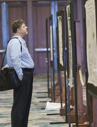 BCI Convention attendee looking at the Poster Research Showcase entries.